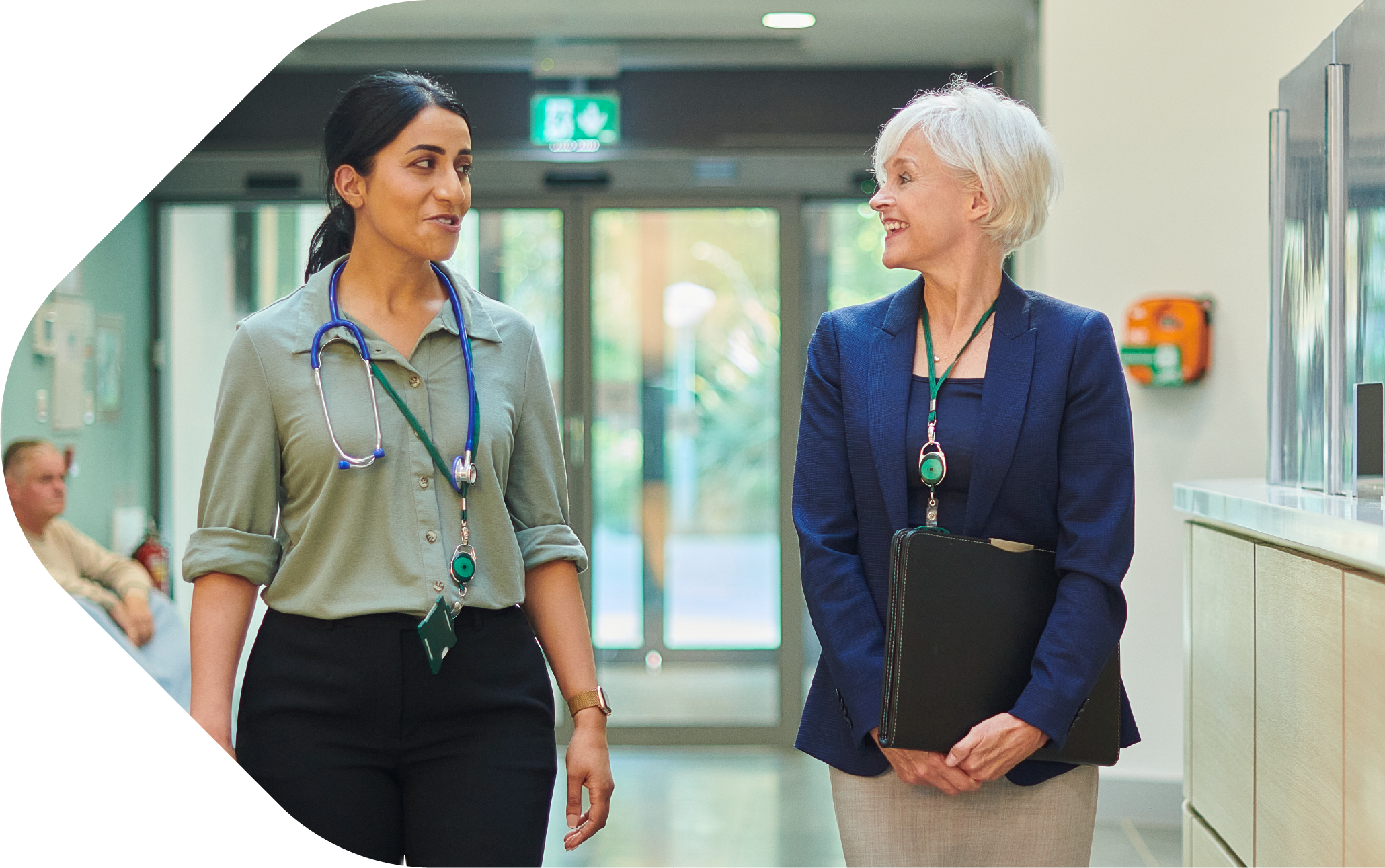 Two clinicians walking through hospital
