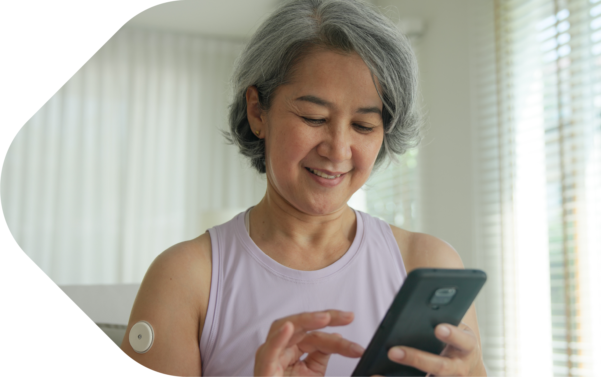 Woman holding smartphone with testing patch on arm